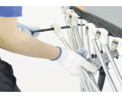 Osoba v rukavicích montuje sušák na prádlo.