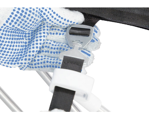 Detailní záběr ruky s pracovní rukavicí, která připevňuje uzávěr k upínacímu popruhu.