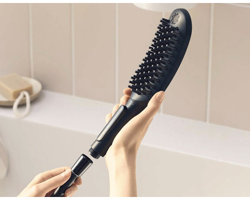 Sprchová hlavice s kartáčem a hadicovou přípojkou v ruce