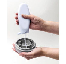 Osoba nalévá tekutinu z láhve do nádoby.