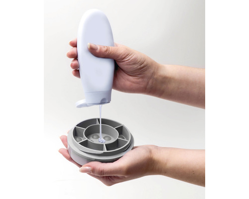 Osoba nalévá tekutinu z láhve do nádoby.