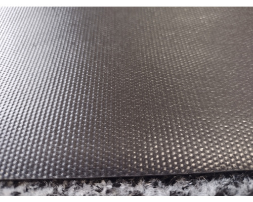 Detailní záběr na černou protiskluzovou podložku s nopkovou strukturou