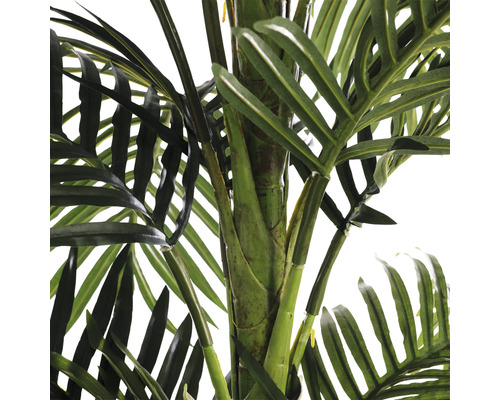 Detailní záběr umělé palmy se zelenými listy a kmenem