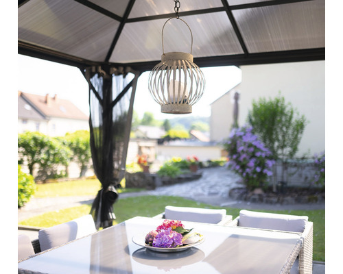 Zahradní altán s jídelním stolem a ozdobnou lucernou