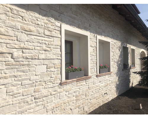 Fasáda domu s parapety a kamenným obkladem