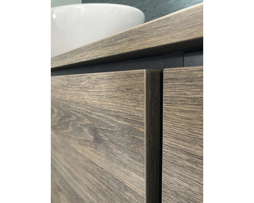 Detailní záběr skříňky pod umyvadlo s dřevěným vzhledem