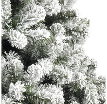 Detailní záběr umělého vánočního stromku se zasněženými větvemi.