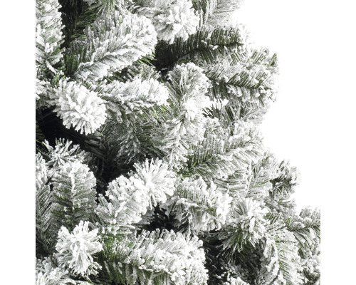 Detailní záběr umělého vánočního stromku se zasněženými větvemi.