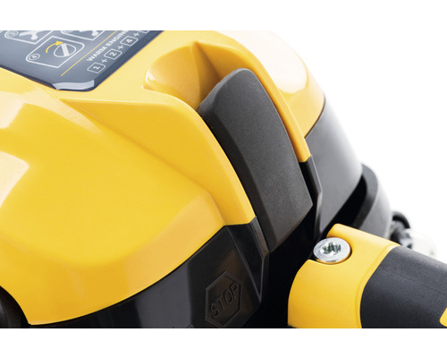 Detailní pohled na žlutou část krytu motoru s vypínačem a značkou stop