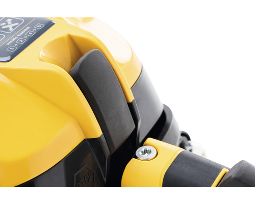 Detailní záběr žlutého zařízení s černou pákou a návodem k obsluze.