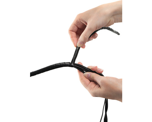 Ruce upevňující černou kabelovou spirálu