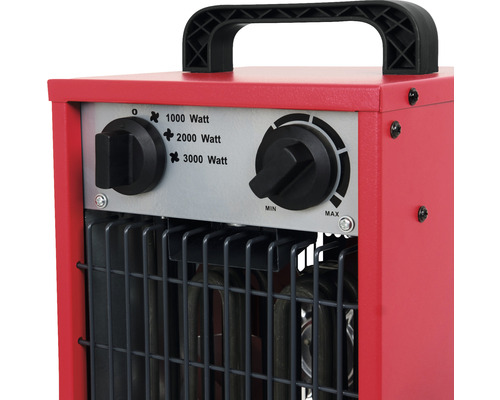Detail červeného elektrického topidla s přepínači pro regulaci výkonu.
