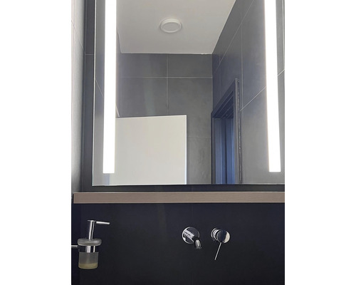 Moderní koupelna s osvětleným zrcadlem a armaturami