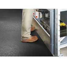 Scéna s osobou stojící před regálem na podložce