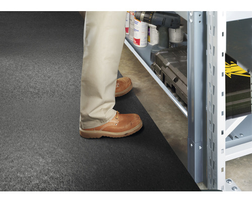 Scéna s osobou stojící před regálem na podložce