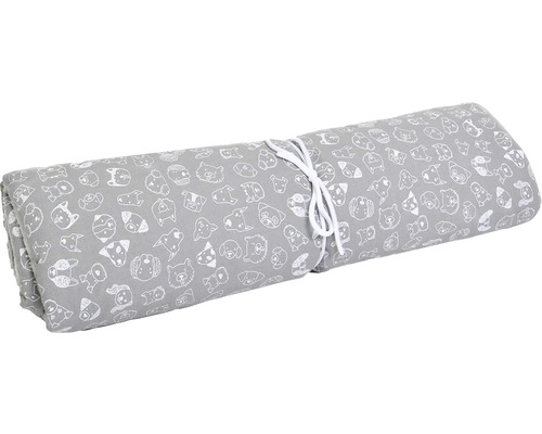 Šedá látka s motivem psů, srolovaná a svázaná provázkem.