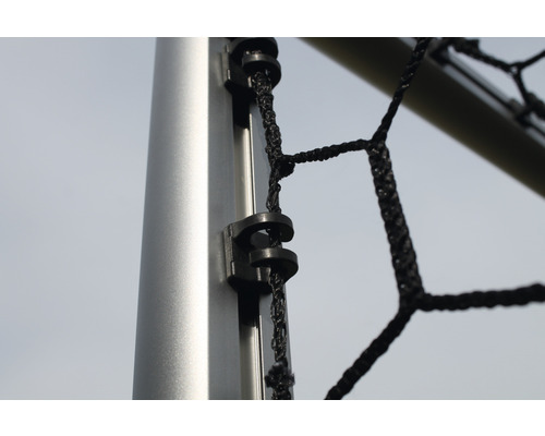 Detailní pohled na upevňovací klip fotbalové sítě na tyči branky