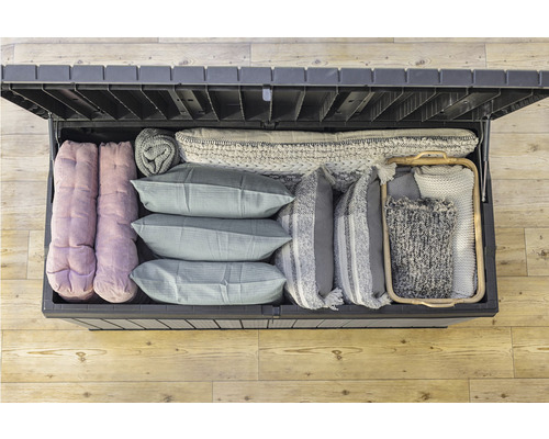 Otevřený úložný box plný polštářů a přikrývek