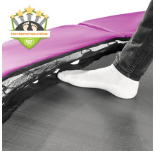 Detailní záběr trampolíny se systémem ochrany nohou a osobou vstupující na skákací plochu