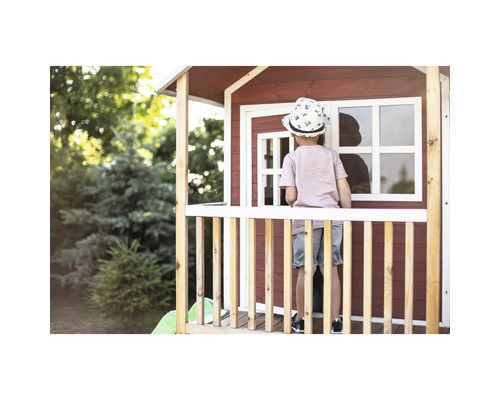 Dítě stojí na verandě dřevěného hracího domku