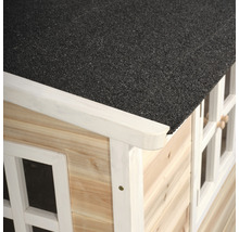 Detailní pohled na dětský domek s dřevěnými stěnami, bílými okenními rámy a černou střechou