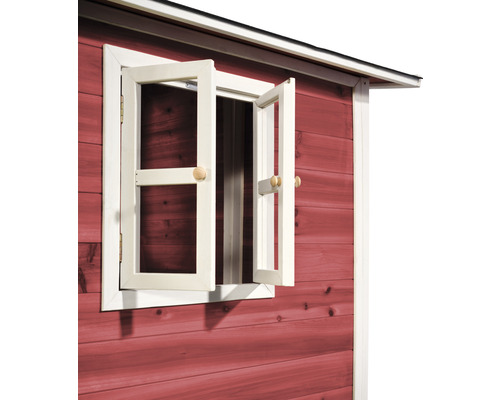 Detailní pohled na červeně natřený zahradní domek s otevřeným oknem