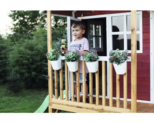 Dítě v domečku na hraní s rostlinami v květináčích