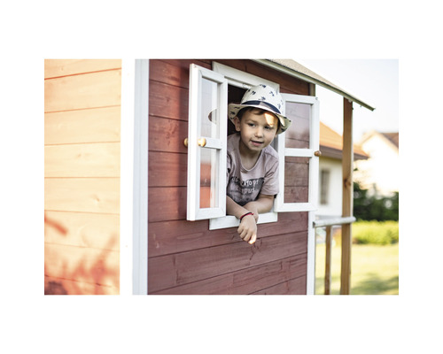 Dítě se dívá z okna hracího domku