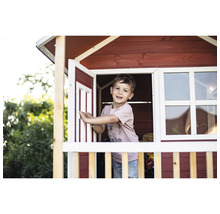 Chlapec si hraje v dřevěném hracím domku s oknem a dveřmi