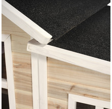 Detailní pohled na zahradní domek s dřevěnou fasádou a bitumentovou střechou