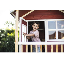 Chlapec v dřevěném hracím domku s oknem a dveřmi