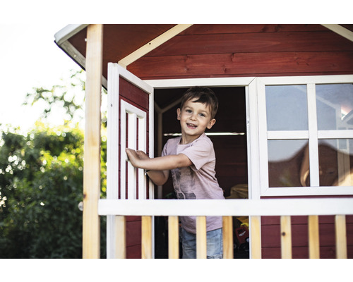 Chlapec v dřevěném hracím domku s oknem a dveřmi