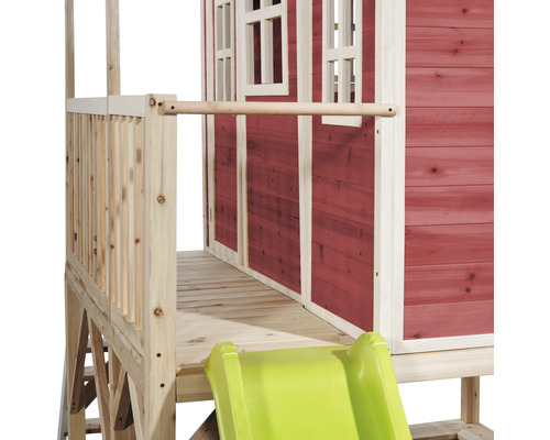 Detailní pohled na herní domek se skluzavkou a dřevěným zábradlím.