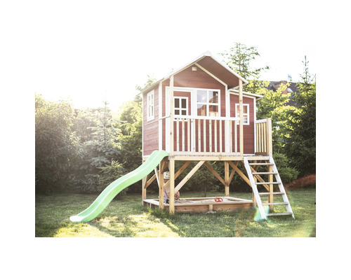 Dřevěný hrací domek se skluzavkou a pískovištěm na zahradě