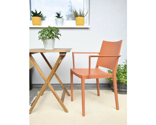 Scéna se zahradním stolem, křeslem a různými rostlinami