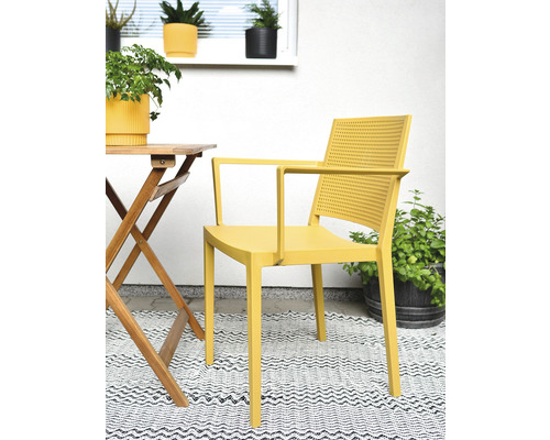 Žluté plastové křeslo na balkoně se stolem a rostlinami