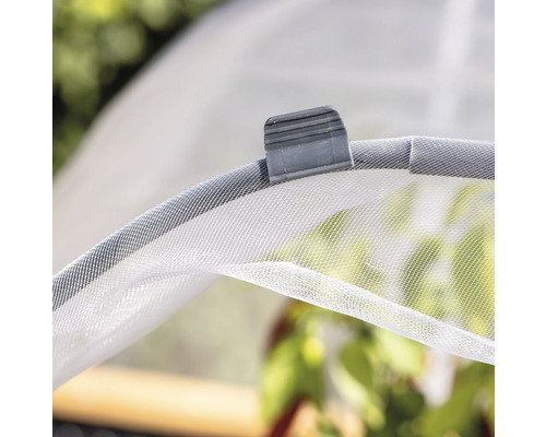 Detailní pohled na rostlinný tunel se síťovým krytem a upevňovací sponou.