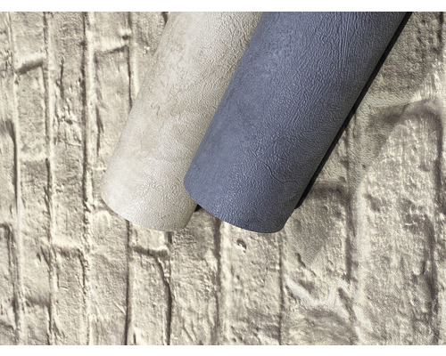 Dvě role strukturované tapety na pozadí cihlové zdi