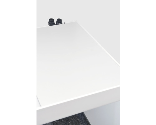 Detail bílého umyvadla se dvěma černými vodovodními bateriemi