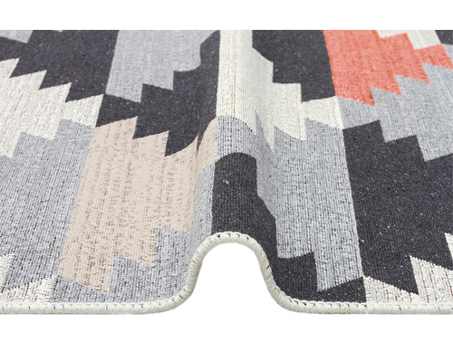 Detailní pohled na vzorovaný koberec s geometrickými tvary.