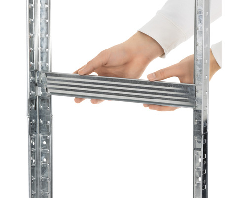 Detailní pohled na osobu vkládající kovový prvek do regálového systému