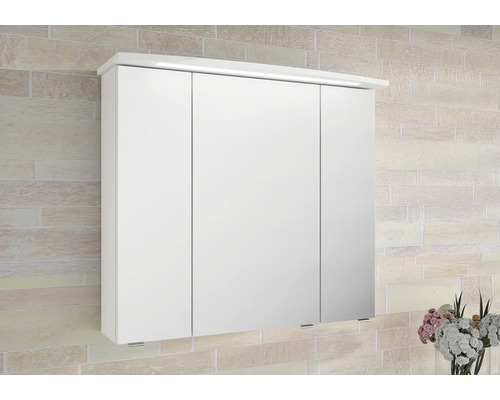 Bílá zrcadlová skříňka se třemi dvířky a osvětlením namontovaná na zdi.