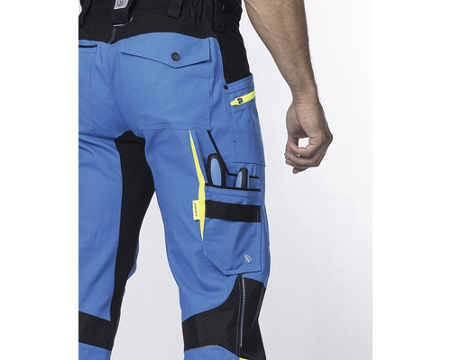 Detailní záběr modrých pracovních kalhot s kapsami a nářadím