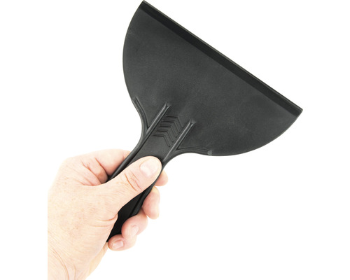 Černá plastová škrabka držená v ruce.