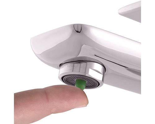 Prst tlačí na perlátor vodovodní baterie.