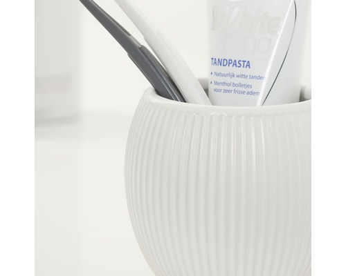 Keramický hrnek s kartáčky na zuby a zubní pastou