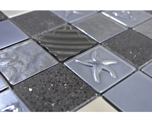 Detailní pohled na mozaikovou dlaždici s hvězdicovými motivy a různými povrchy