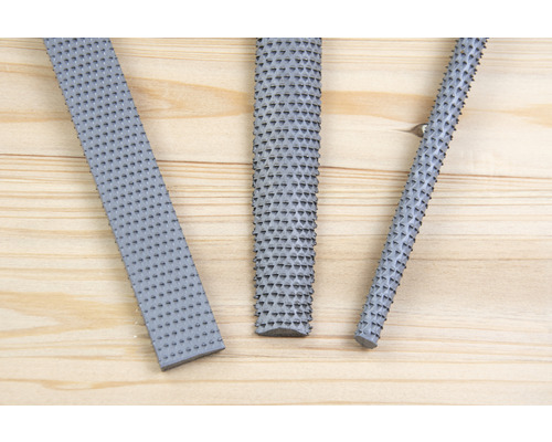 Tři rašple na dřevo na dřevěném pozadí