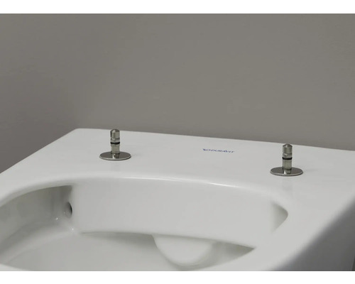 Detailní pohled na bílou toaletu Duravit s upevňovacími šrouby