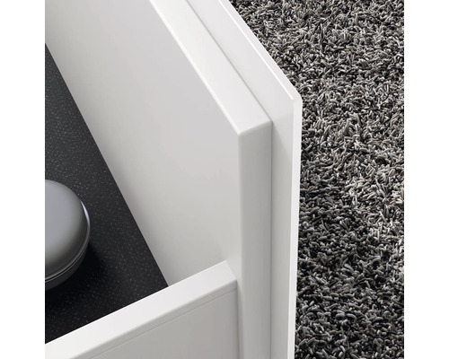 Detailní záběr bílé koupelnové skříňky s kobercem